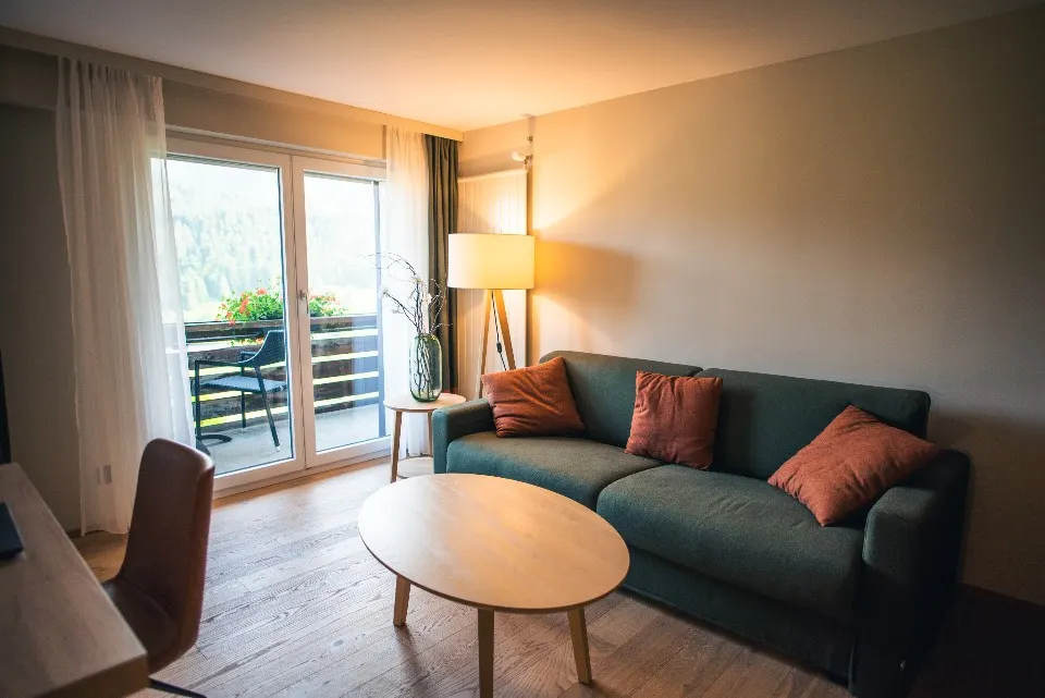 Lichte woonkamer van een appartement met zetel, salontafel en balkon